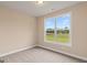 Bedroom with neutral carpet and large window with views of an open field at 123 Oak Road, Locust Grove, GA 30248
