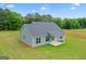 Green home featuring a gray roof, lush yard, and covered back porch at 123 Oak Road, Locust Grove, GA 30248