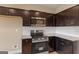 This kitchen boasts dark cabinets, granite countertops, stainless steel microwave and range oven at 123 Oak Road, Locust Grove, GA 30248