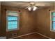 Bedroom featuring wood paneling, two windows, and a ceiling fan at 4720 Ben Hill Rd, South Fulton, GA 30349