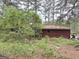 The brick house exterior is nestled amidst trees and lush plants, with some yard debris at 4720 Ben Hill Rd, South Fulton, GA 30349