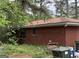Exterior of a brick home including the side view of the house, windows, yard debris and trees at 4720 Ben Hill Rd, South Fulton, GA 30349