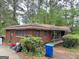 Exterior view of the house featuring a classic brick facade, a front porch, and some yard debris at 4720 Ben Hill Rd, South Fulton, GA 30349