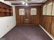 Living room features wood paneled walls, ceiling fan, and a brick accent wall at 4720 Ben Hill Rd, South Fulton, GA 30349