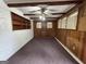 Spacious living area featuring wood paneling, ceiling beams, fan, and shelving at 4720 Ben Hill Rd, South Fulton, GA 30349