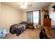 Cozy bedroom featuring neutral walls, a comfortable bed, ceiling fan, and a large window at 361 N Dogwood Ave, Social Circle, GA 30025