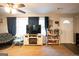 Cozy living room with a ceiling fan, large windows, and light colored carpet at 361 N Dogwood Ave, Social Circle, GA 30025