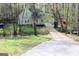 Secluded two-story home in the woods, featuring a charming porch and a long driveway leading to the property at 142 Kylee Ct, Villa Rica, GA 30180