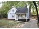Charming two-story home with a cozy front porch, a balcony, and mature trees surrounding the property at 142 Kylee Ct, Villa Rica, GA 30180