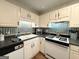 Functional kitchen with white cabinets, black countertops, modern appliances, and a charming backsplash at 142 Kylee Ct, Villa Rica, GA 30180