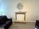 A cozy living room with a stone fireplace, wood-look tile flooring, and comfortable dark couches at 142 Kylee Ct, Villa Rica, GA 30180