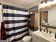 Bathroom with shower featuring blue and white striped curtain, cabinet storage and white vanity at 324 Bells Ferry Ne Rd, White, GA 30184