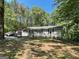 Charming single-story home with a large yard surrounded by trees and a long driveway at 324 Bells Ferry Ne Rd, White, GA 30184