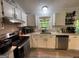 The kitchen has white cabinets, stainless steel appliances and lots of natural light at 324 Bells Ferry Ne Rd, White, GA 30184
