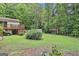 The large grassy backyard features mature trees, a deck, a storage shed, and a charming gazebo at 502 Pine Cir, Peachtree City, GA 30269