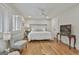 Bright bedroom with hardwood floors, a ceiling fan, a bed, and windows with white shutters at 502 Pine Cir, Peachtree City, GA 30269