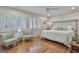 Bright bedroom with hardwood floors, a ceiling fan, and windows with white shutters at 502 Pine Cir, Peachtree City, GA 30269