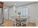 Bright dining area features wood floors, white walls, and a round wood table with white chairs and shuttered windows at 502 Pine Cir, Peachtree City, GA 30269