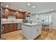 Well lit kitchen boasts hardwood floors, stainless steel appliances, and a white island with a stone countertop at 502 Pine Cir, Peachtree City, GA 30269