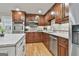Modern kitchen with stainless steel appliances, wood cabinets, and tile backsplash at 502 Pine Cir, Peachtree City, GA 30269
