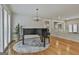 Bright living room features hardwood floors, a piano, and white painted brick at 502 Pine Cir, Peachtree City, GA 30269