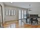 Bright living room featuring hardwood floors, a piano, and glass double doors at 502 Pine Cir, Peachtree City, GA 30269