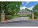 Stately brick home featuring a circular driveway, lush landscaping, and two decorative lion statues at the entrance at 2795 Hawthorne Dr, Atlanta, GA 30345