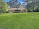 Expansive backyard featuring a deck, screened porch, and lush green lawn at 120 Rolling Brook Trl, Fayetteville, GA 30215