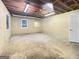 Unfinished basement features exposed beams, concrete floor, and natural light from two windows at 120 Rolling Brook Trl, Fayetteville, GA 30215