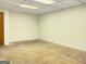 Empty room in the basement with a dropped ceiling and concrete flooring at 120 Rolling Brook Trl, Fayetteville, GA 30215