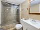 Bathroom featuring a large glass enclosed shower, neutral tile, white vanity, and wood framed mirror at 120 Rolling Brook Trl, Fayetteville, GA 30215
