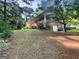View of the home from the side showing garage entrance, lush landscaping, and brick exterior at 120 Rolling Brook Trl, Fayetteville, GA 30215