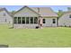 Back view of a white home with a screened-in porch and a well-maintained backyard at 82 Airmont Dr, Sharpsburg, GA 30277