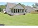 A large, grassy backyard featuring a white home with a screened-in porch, perfect for outdoor activities at 82 Airmont Dr, Sharpsburg, GA 30277