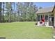 A spacious, grassy backyard with a white home and screened-in porch, ideal for relaxation and recreation at 82 Airmont Dr, Sharpsburg, GA 30277