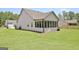 Back view of a white home featuring a well-maintained backyard and a screened-in porch at 82 Airmont Dr, Sharpsburg, GA 30277