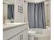 Bathroom featuring a toilet and shower with blue shower curtain, vanity, and a tiled wall at 82 Airmont Dr, Sharpsburg, GA 30277