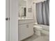 Bathroom featuring a toilet and shower with blue shower curtain, and vanity with cabinet storage at 82 Airmont Dr, Sharpsburg, GA 30277