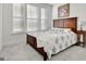 Inviting bedroom featuring a full-size bed, neutral carpet, and well-lit with natural light streaming through the windows at 82 Airmont Dr, Sharpsburg, GA 30277