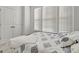 Well-lit bedroom with a full-size bed, multiple windows, plush carpet, and a closet in a neutral color palette at 82 Airmont Dr, Sharpsburg, GA 30277