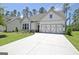 Inviting single-Gathering home showcasing a manicured lawn, decorative garage door, and concrete driveway at 82 Airmont Dr, Sharpsburg, GA 30277