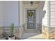 Stylish entryway showcasing a gray front door with decorative wreath, stone accents, and manicured landscaping at 82 Airmont Dr, Sharpsburg, GA 30277