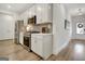 Stylish kitchen featuring stainless steel appliances, white cabinets, and wood grain flooring at 82 Airmont Dr, Sharpsburg, GA 30277