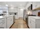 Beautiful kitchen with white cabinets, stainless steel appliances, and a gray subway tile backsplash at 82 Airmont Dr, Sharpsburg, GA 30277