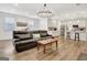 Open-concept living room with a leather sofa, wood floors, and kitchen view at 82 Airmont Dr, Sharpsburg, GA 30277