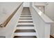 Staircase with wood treads and white risers and banister leading to an upper level at 82 Airmont Dr, Sharpsburg, GA 30277
