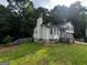 View of the side of the house showing the siding, deck, chimney, and the natural landscape at 1504 Colt Ridge Se Ln, Mableton, GA 30126