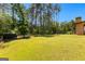 Large, well-maintained backyard featuring lush green grass, mature trees, and a fenced area at 105 Turnberry Trce, Sharpsburg, GA 30277