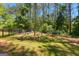 Well-manicured backyard featuring a fenced garden with mature trees at 105 Turnberry Trce, Sharpsburg, GA 30277