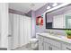 Stylish bathroom with lilac walls, white vanity, granite countertop, and decorative floral art at 105 Turnberry Trce, Sharpsburg, GA 30277
